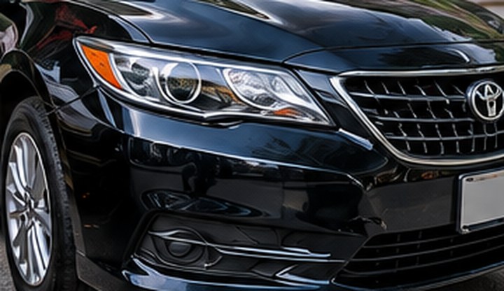 Black Toyota Camry front end after repair, with new headlight and grille